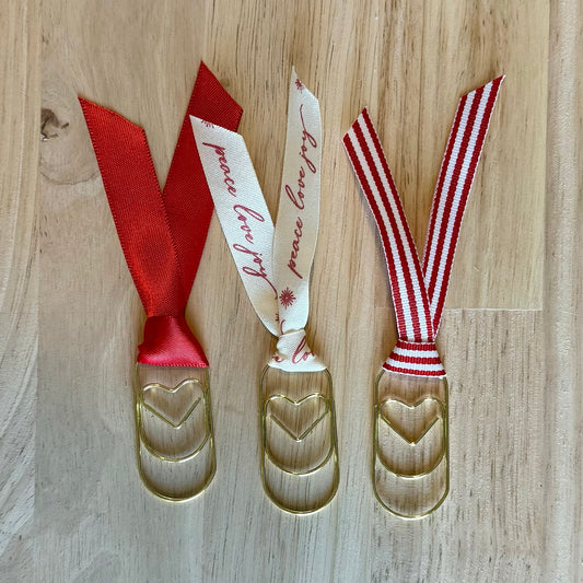 Christmas Red example set of 3 ribbon paperclip bookmarks: red, cream "peace love joy" and red-and-white stripe ribbons. Ribbons in your set will vary.