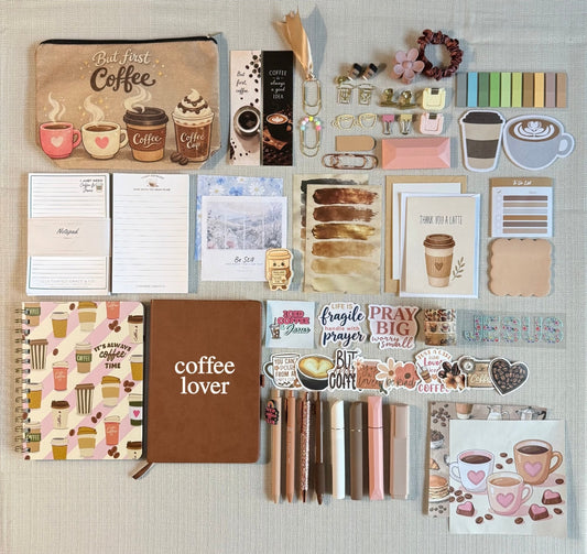 Full contents of The Coffee Lover Box laid out, two journals, two coffee notepads, zip pouch, pens, highlighters, cards, stickers and accessories