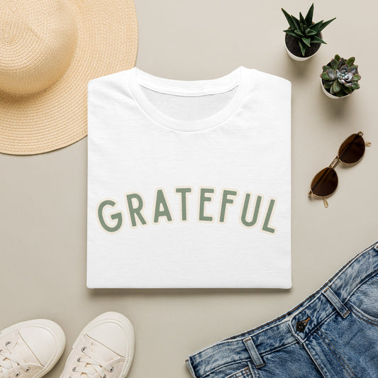 Grateful Softstyle T-Shirt in White, sage green arched GRATEFUL lettering with cream outline, folded flat lay