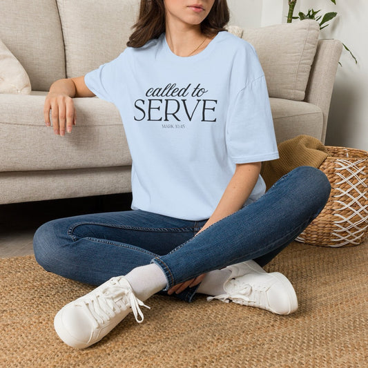 Woman seated wearing the Called to Serve tee in Light Blue with jeans and white sneakers