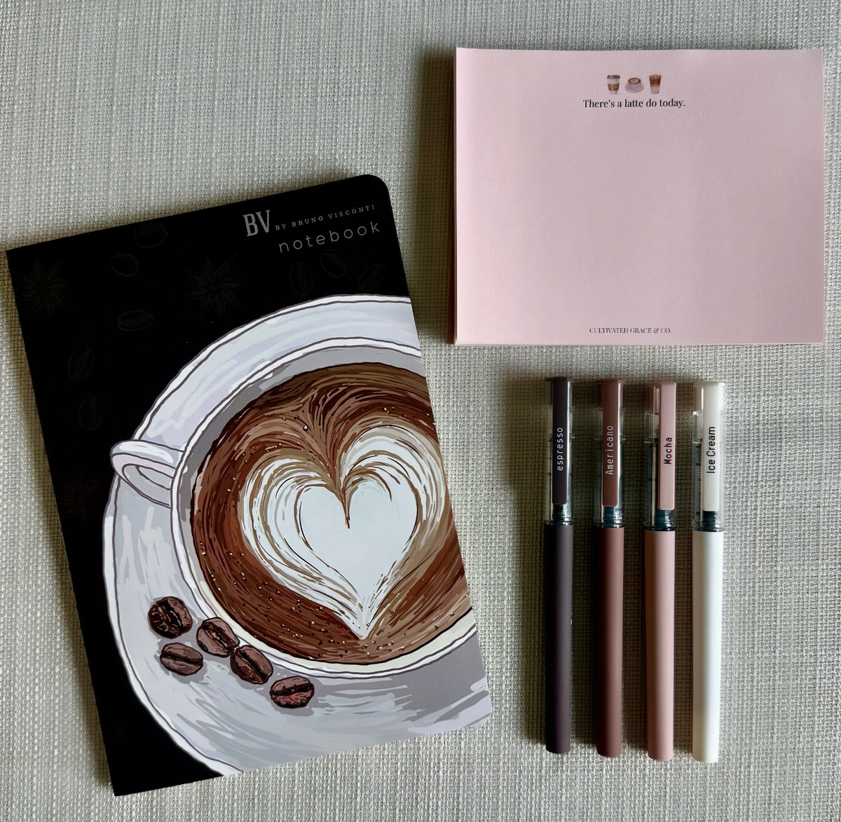 Coffee Lover Add-on Bundle: latte heart notebook, four coffee pens and There's a Latte Do Today notepad laid flat