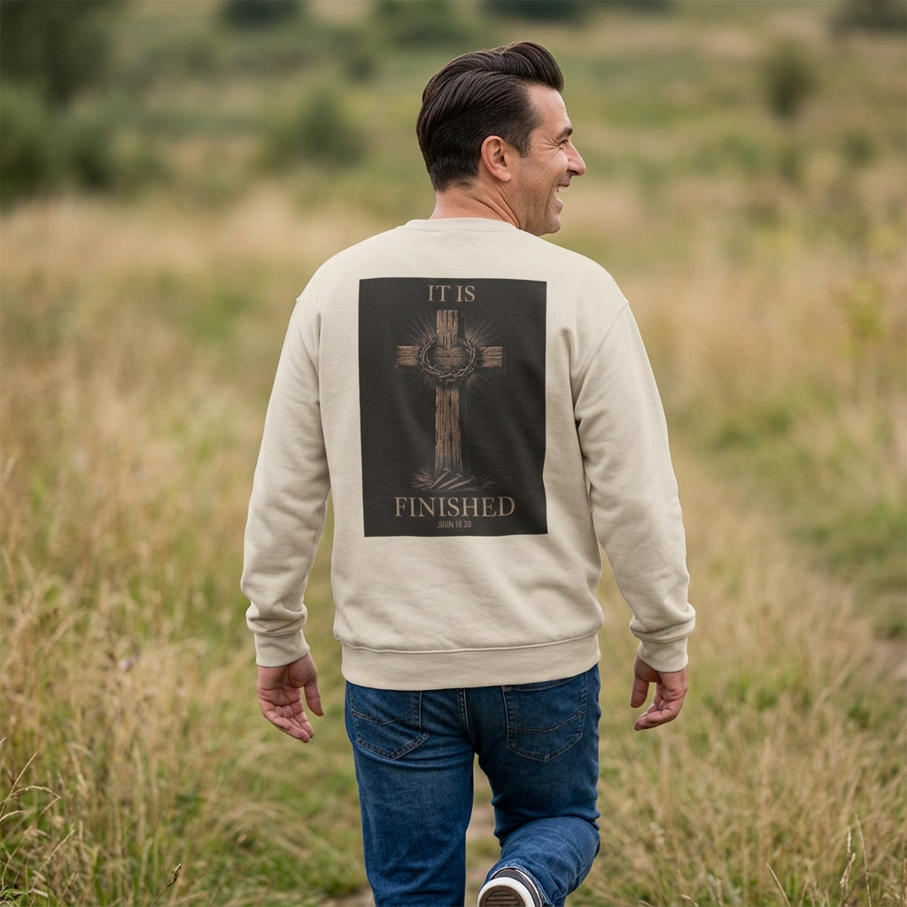 Man walking outdoors in the It Is Finished crewneck sweatshirt in Sand, back view