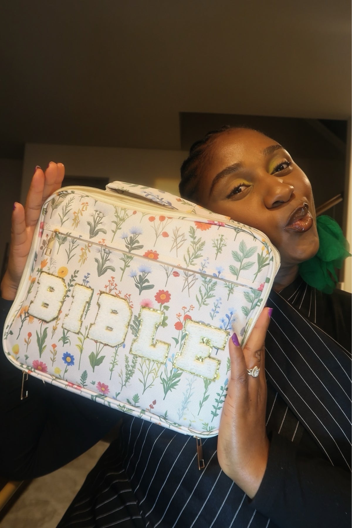 Natalie holding the Wildflowers chenille zip Bible case with white BIBLE letters beside her face