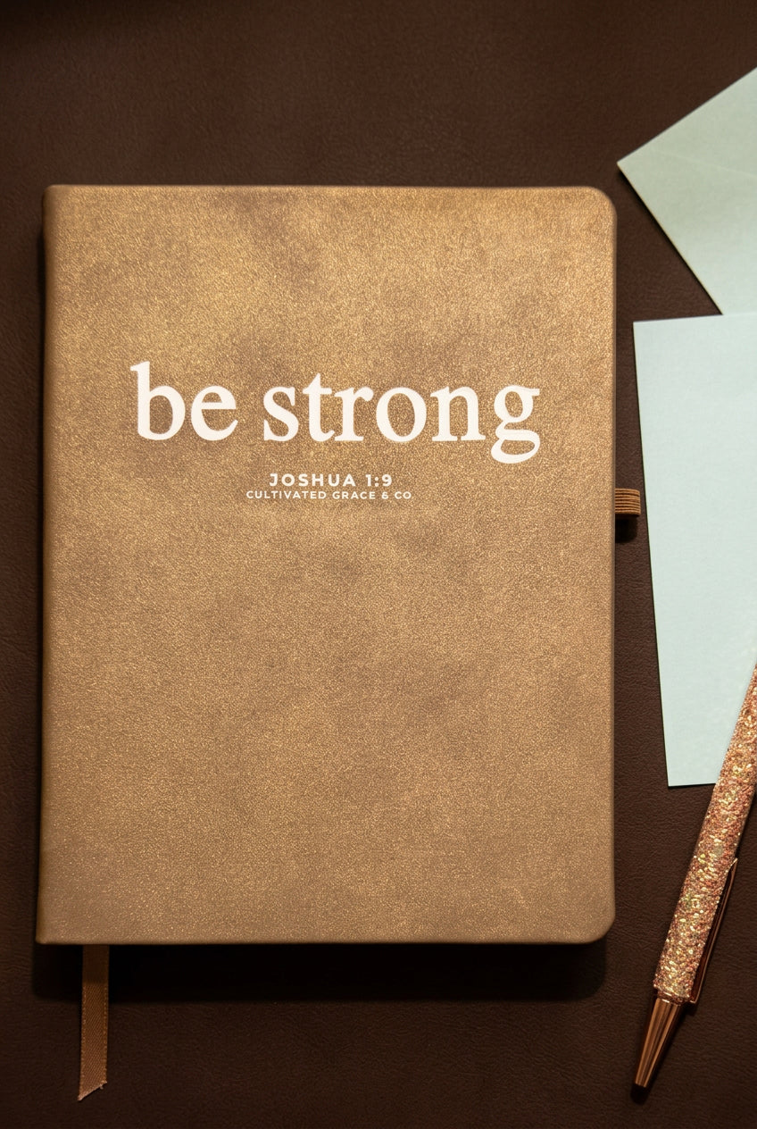 Be Strong faith word journal in Shimmer Brown, styled with a pen and envelopes