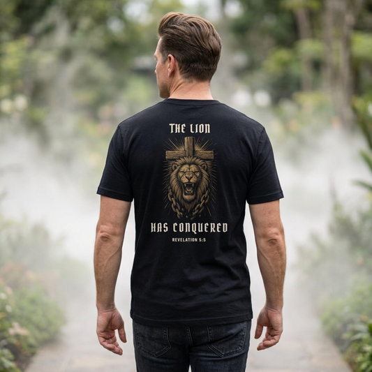 Man wearing The Lion Has Conquered tee in Black, showing lion and cross back artwork with Revelation 5:5